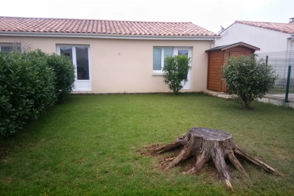 Souche gênante avant rognage dans un jardin à Aytré